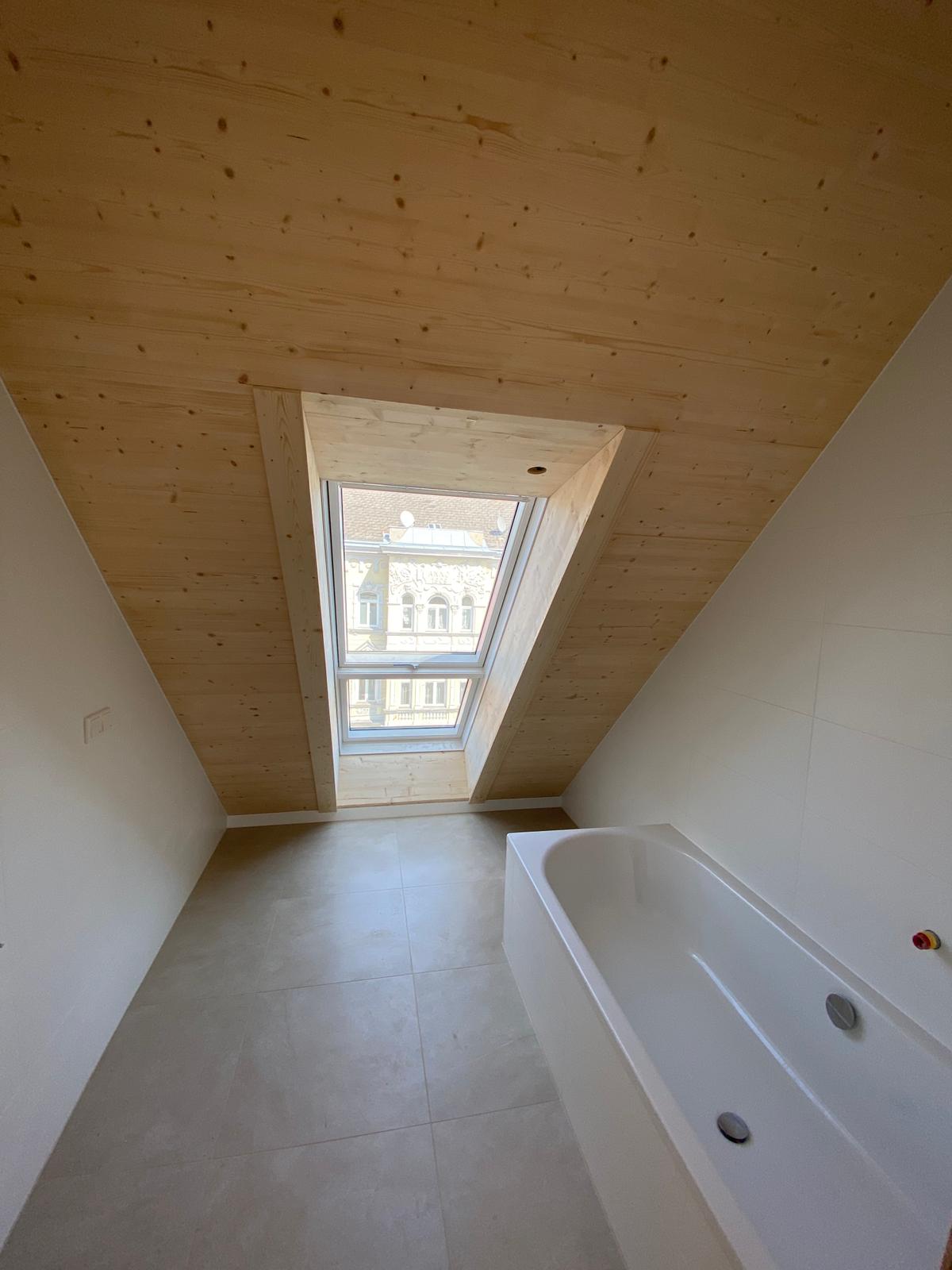 Badezimmer in Dachschraege mit Sichtholzdecke